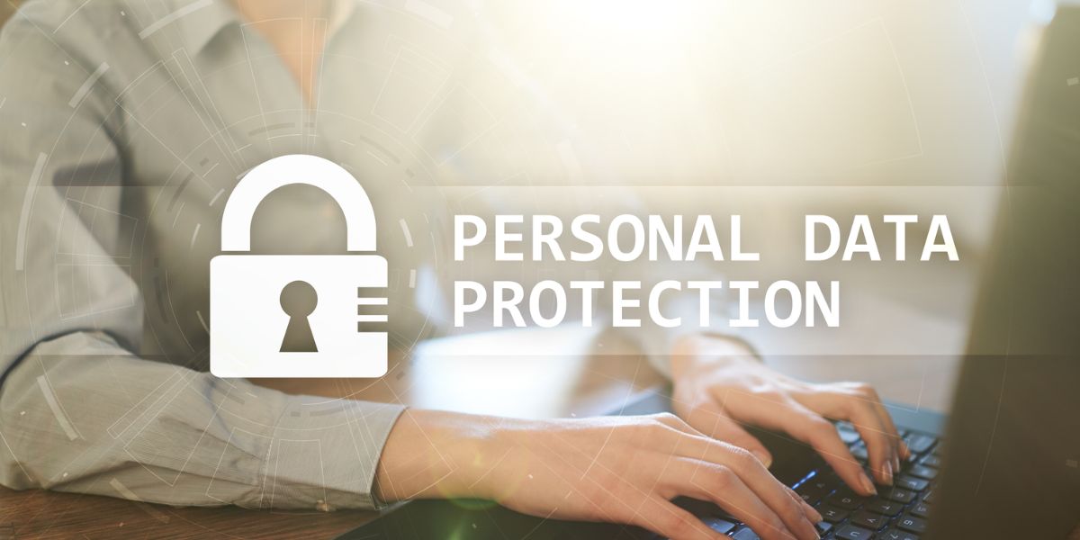 Digital overlay of a padlock icon and "PERSONAL DATA PROTECTION" text over a person typing on a laptop